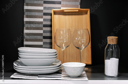 Glass wine glasses and ceramic plates in the kitchen interior.