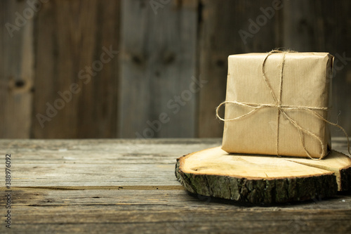 Tło świąteczne z dekoracją, prezent na drewnianej desce. Temat podarunków z okazji Bożego Narodzenia