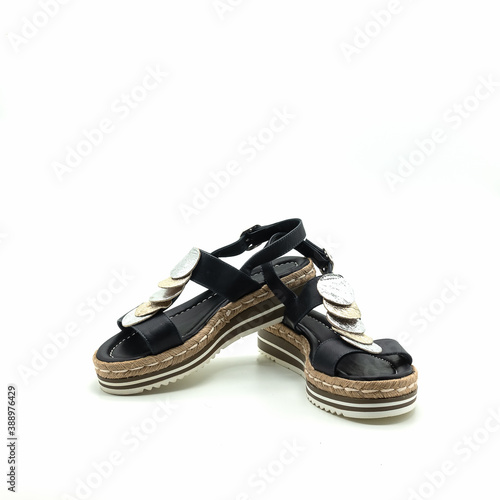 Summer women's sandals made of genuine leather. The straps are dark blue, decorated with silver and gold circles. The thick flat sole is stitched with threads. Isolated over white background.