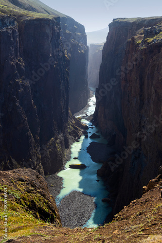 Breathtaking view of Hafrahvammar canyon in East Iceland. High canyon walls and turquoise glacier river below.