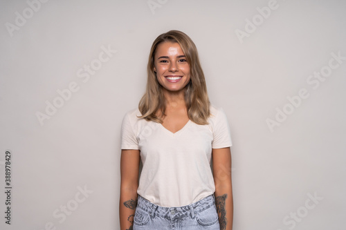 Young positive woman with long hair wearing t-shirt and jeans isolated on white background