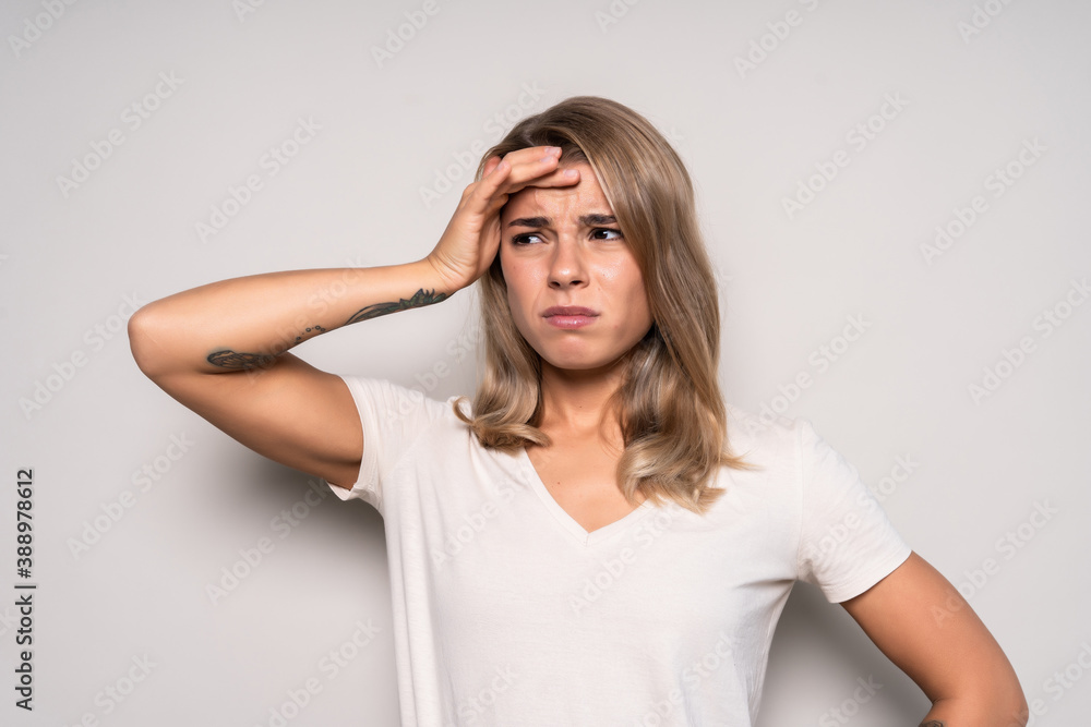 Young woman with a headache holding head, isolated on white background