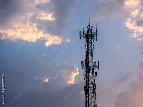 In the early morning, under the background of blue sky and white clouds, the wireless telex tower and the wired electric tower