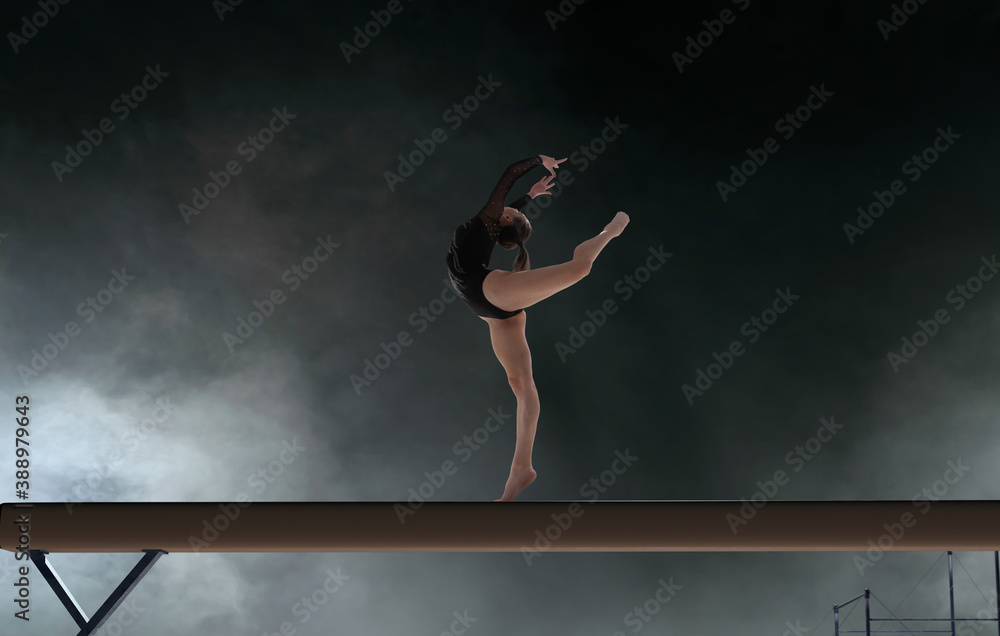 Female gymnast doing a complicated trick in a professional arena.