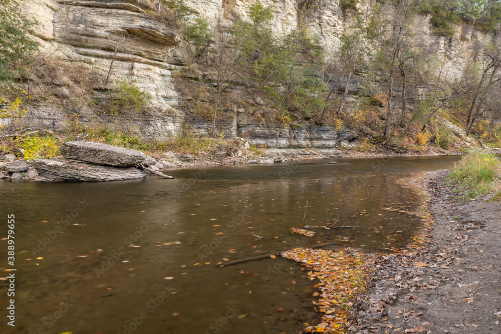 Root River In Autumn - A scenic river next to a cliff. Root River In Autumn - A scenic river next to a cliff.