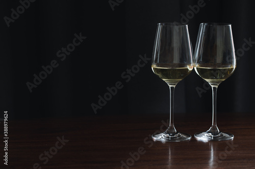 two glasses white wine in hotel room. Close-up a Glass of white wine is on the table. Warm cozy atmosphere, festive table, a glass of champagne on the table.