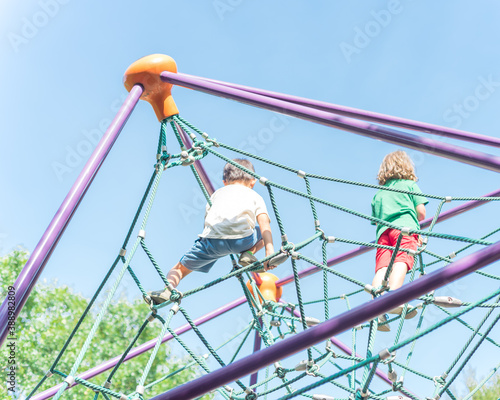 Upward view of multiethnic diverse kids on climbing dome at playground near Dallas, Texas, USA