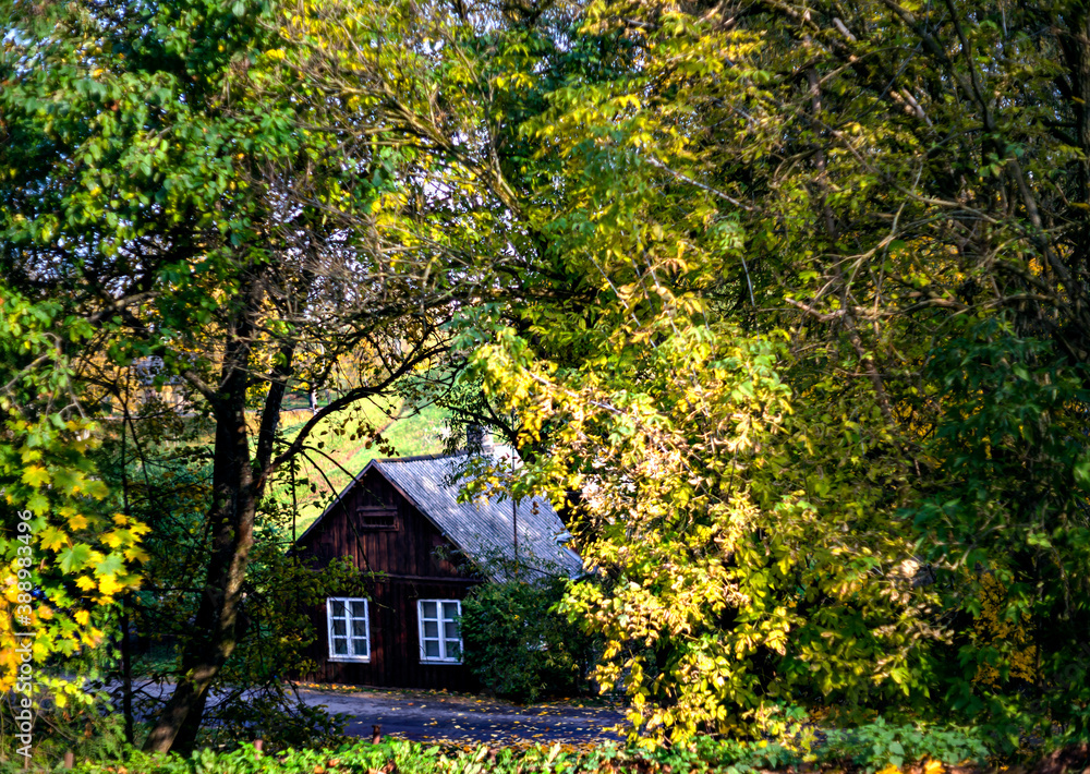 Defocused blurred autumn background with old house