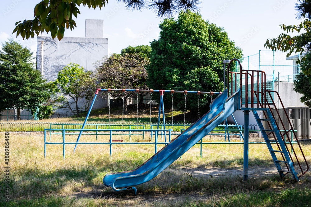 Fototapeta premium 青いブランコと滑り台のある公園