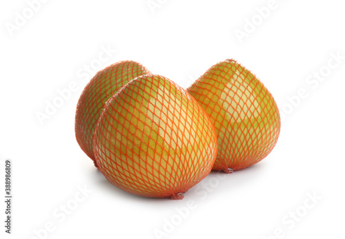Fresh pomelo fruits in meshes isolated on white