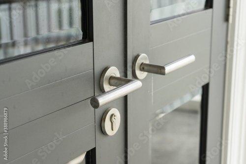 Silver door handle on black door. Furniture accessories, interior element