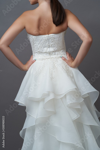 Beautiful bride in wedding dress posing on grey background