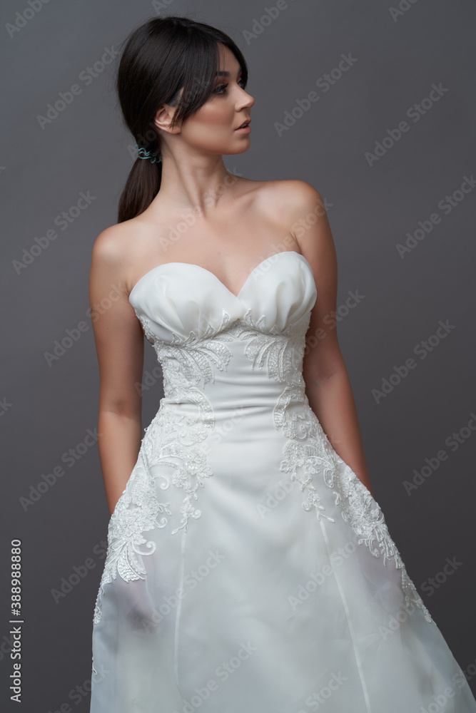 Beautiful bride in wedding dress posing on grey background with copy space. Beautiful bride in wedding dress posing on grey background with copy space.