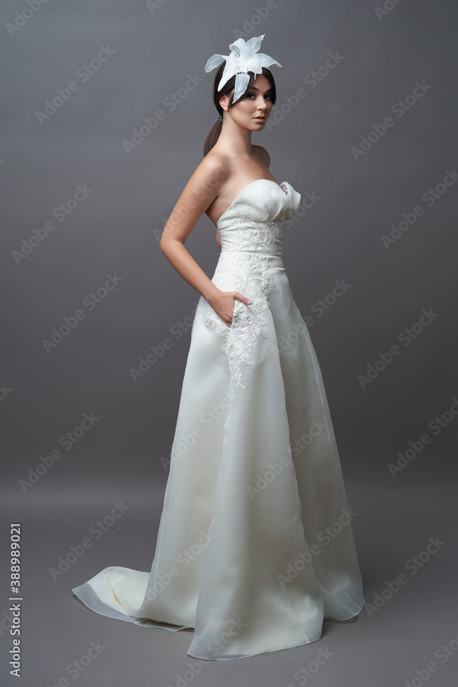 Beautiful bride in wedding dress posing on grey background with copy space. Beautiful bride in wedding dress posing on grey background with copy space.