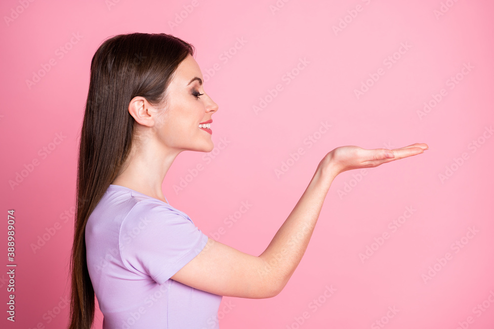 Profile photo of attractive charming cute lady hold open hand arm palm novelty charity concept showing new product wear casual purple t-shirt isolated pink pastel color background Profile photo of attractive charming cute lady hold open hand arm palm novelty charity concept showing new product wear casual purple t-shirt isolated pink pastel color background