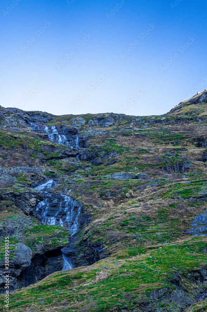 Obraz premium Waterfall free falling from a steep mountain slope. 