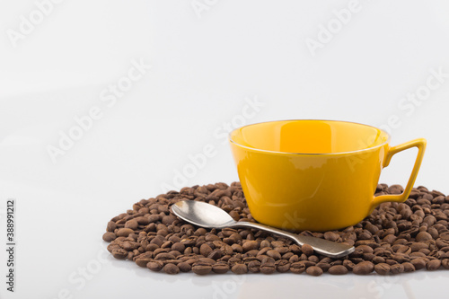 Coffee in yellow cup and coffee beans isolated.