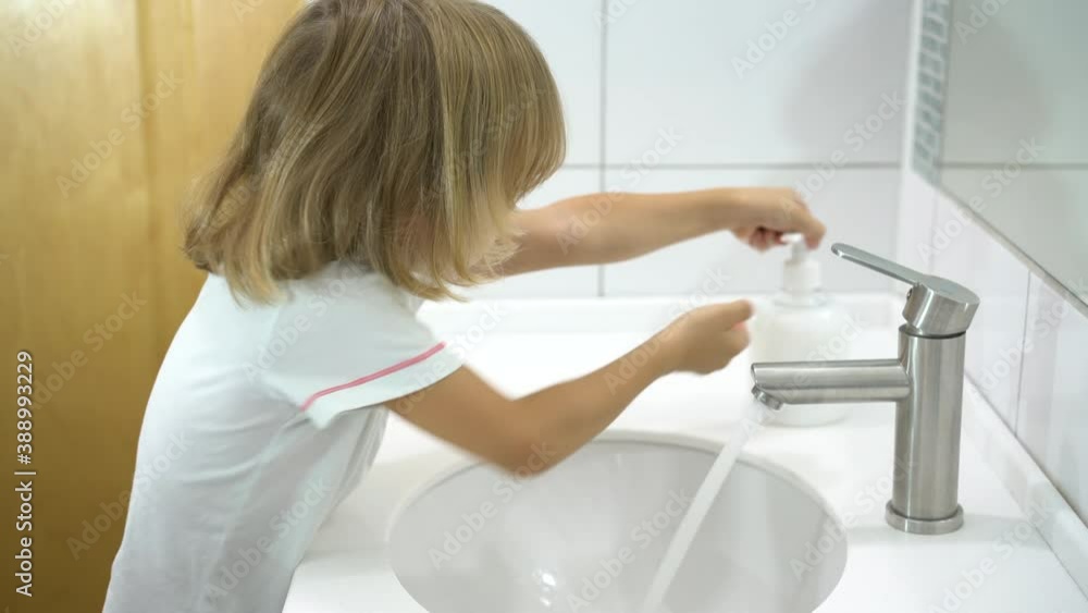 Cute little blond boy washing his hands with a liquid soap over the sink with running water. Clean hand concept idea. Play with foam. Health care, protection against coronavirus COVID-19. Cute little blond boy washing his hands with a liquid soap over the sink with running water. Clean hand concept idea. Play with foam. Health care, protection against coronavirus COVID-19.