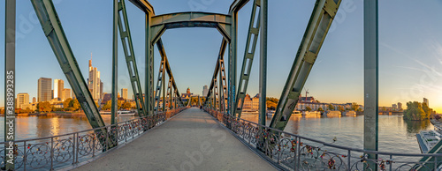 Fotografia eiserner Steg, famous iron footbridge crosses river Main in Frankfurt with skyli