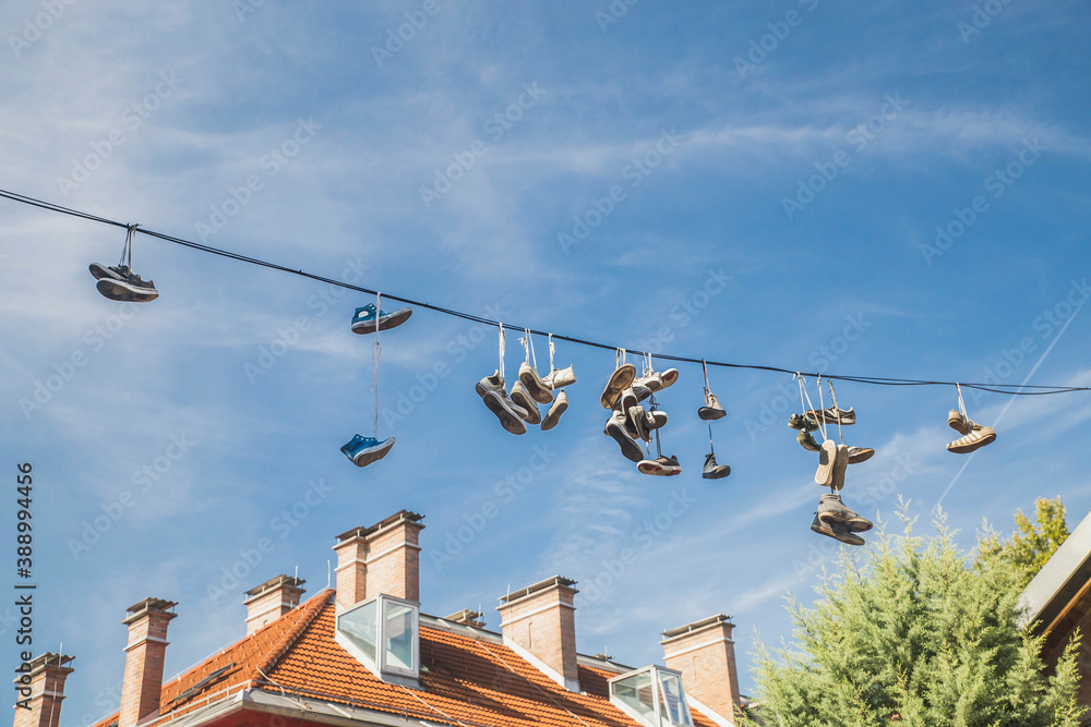 Old worn-out shoes hang from wires in slovenia Old worn-out shoes hang from wires in slovenia