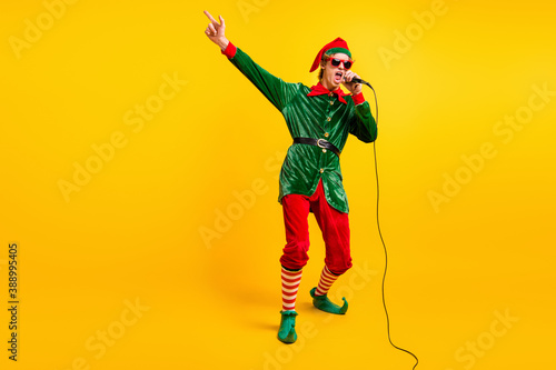 Full length body size view of his he nice attractive cool talented funny guy elf mc pj dj singing hit having fun festal day isolated over bright vivid shine vibrant yellow color background