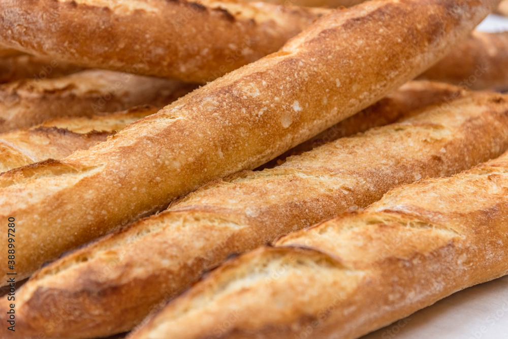 Freshly baked French baguettes lie on a light-colored surface. Rustic handicraft bread, handmade Freshly baked French baguettes lie on a light-colored surface. Rustic handicraft bread, handmade