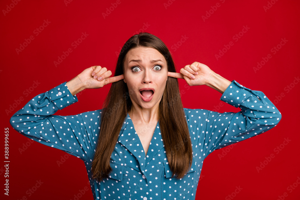 Close-up portrait of attractive crazy desperate girl closing ears isolated over bright red color background Close-up portrait of attractive crazy desperate girl closing ears isolated over bright red color background