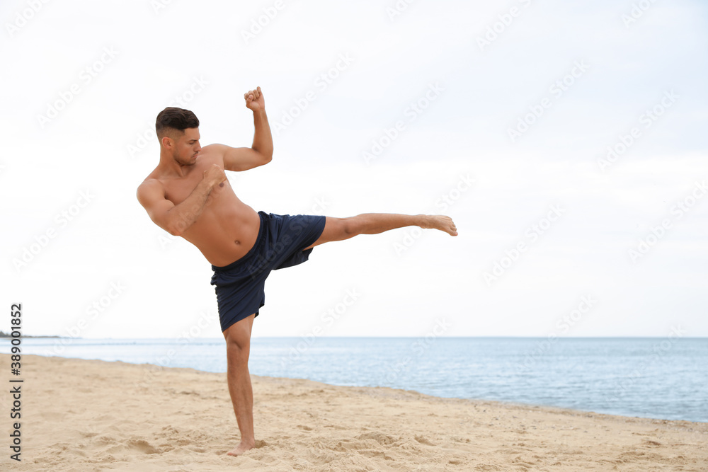 Muscular man doing exercise on beach. Body training Muscular man doing exercise on beach. Body training