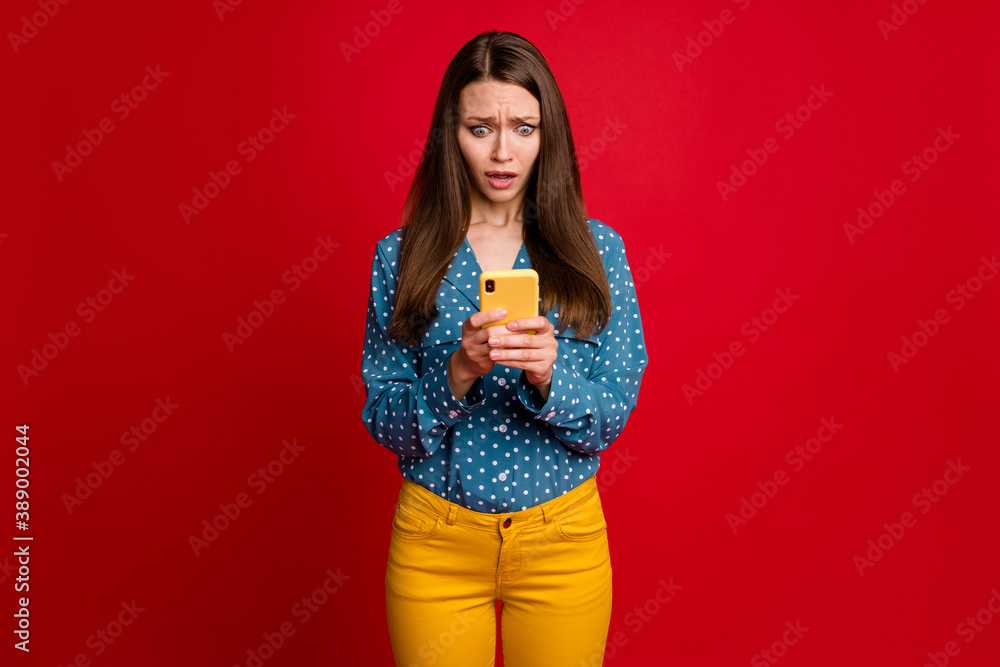 Portrait of attractive desperate nervous girl using device browsing fake news isolated over bright red color background Portrait of attractive desperate nervous girl using device browsing fake news isolated over bright red color background