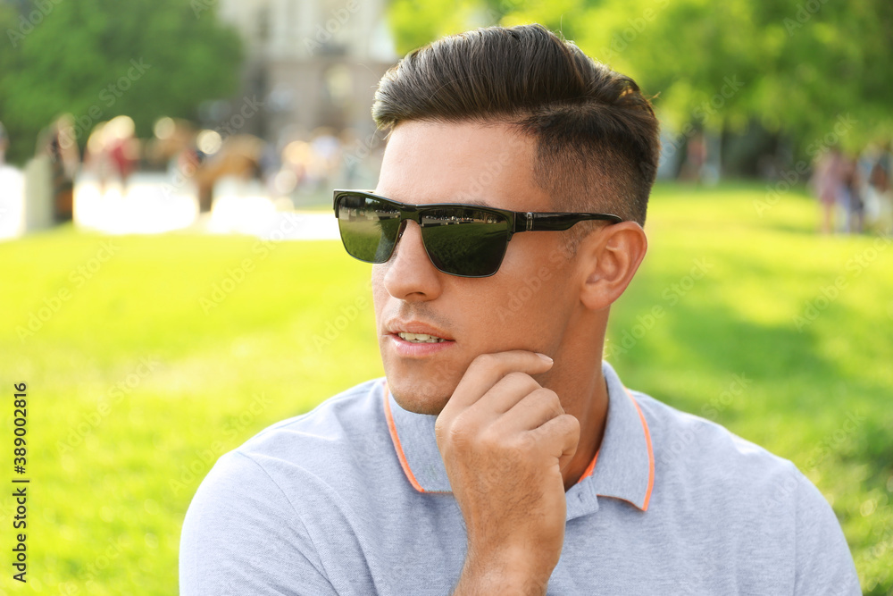 Handsome man wearing stylish sunglasses in park Handsome man wearing stylish sunglasses in park