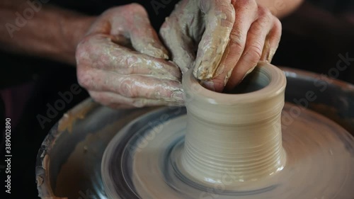 Ceramist uses potter's wheel and creates a handmade clay product. photo