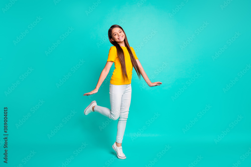 Full length photo of pretty kid girl standing isolated over turquoise color background Full length photo of pretty kid girl standing isolated over turquoise color background