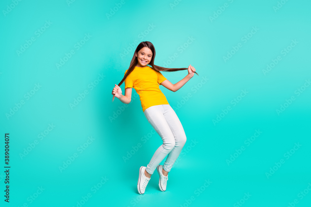 Full body photo of positive kid girl hold her haircut dancing isolated over teal color background