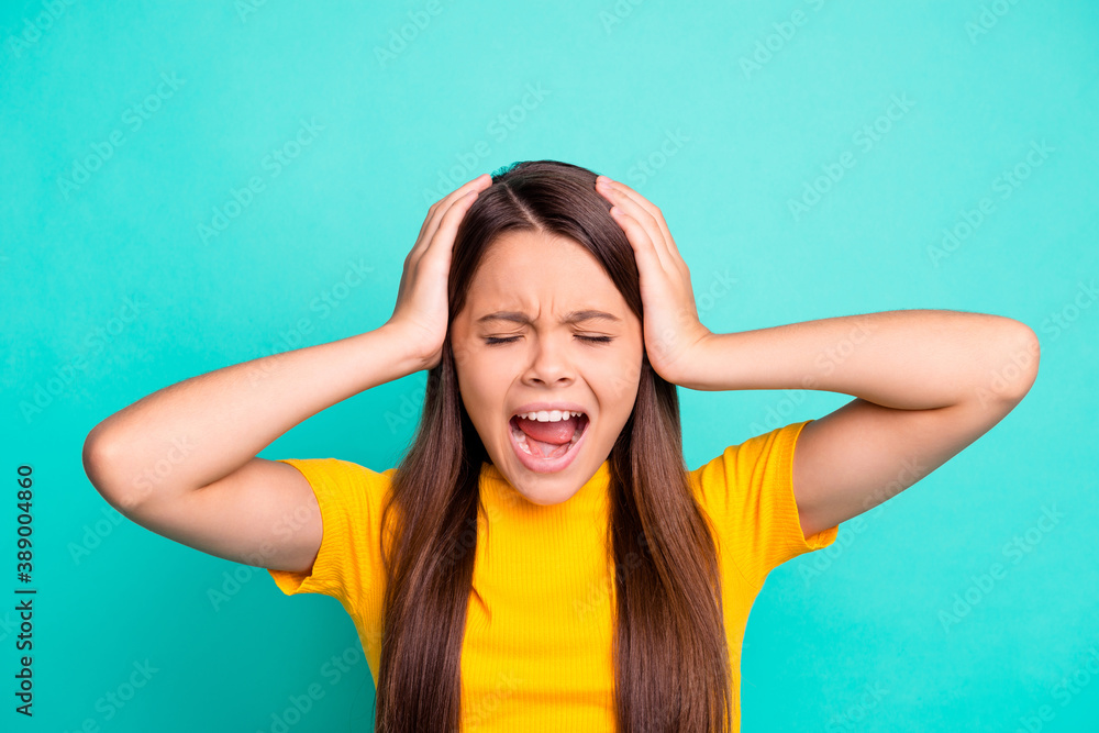 Photo of angry kid girl touch hands head shout wear casual bright style clothes isolated over teal color background Photo of angry kid girl touch hands head shout wear casual bright style clothes isolated over teal color background