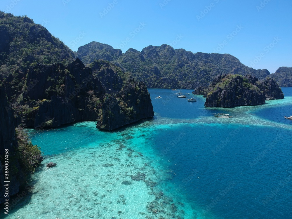 drone view of the open sea, coral reef, diving and snorkeling area, limestone rocks, Philippine boats in Coron Palawan