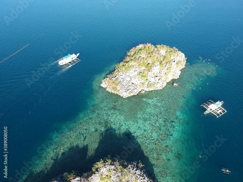 drone view of the open sea, coral reef, diving and snorkeling area, limestone rocks, Philippine boats in Coron Palawan