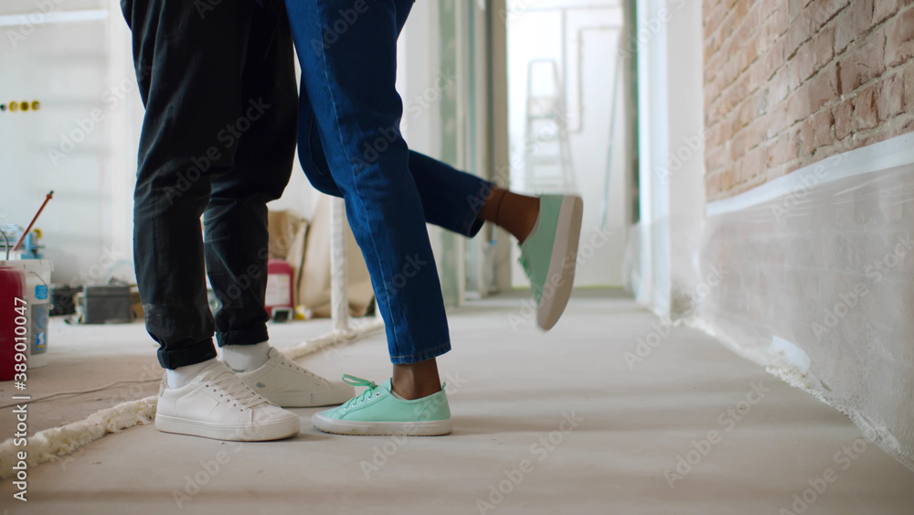 Close up of male and female legs over renovating house background Close up of male and female legs over renovating house background