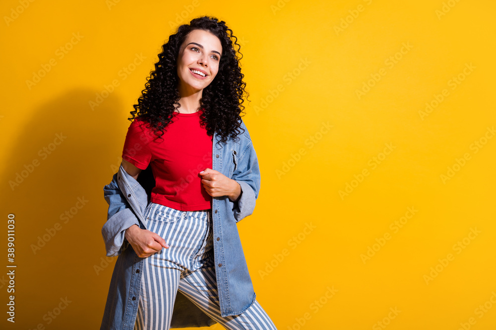 Photo of lovely lady look empty space beaming smile wear striped jeans red t-shirt jacket isolated yellow color background Photo of lovely lady look empty space beaming smile wear striped jeans red t-shirt jacket isolated yellow color background