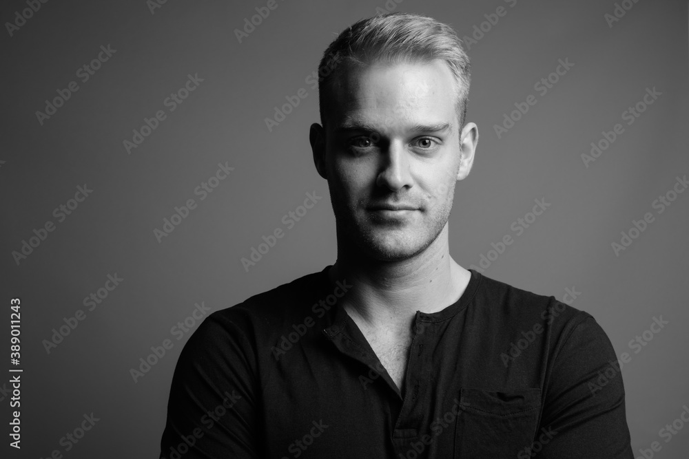 Obraz premium Young handsome man with blond hair against gray background