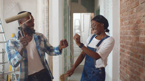 African couple dancing doing home repair and having fun
