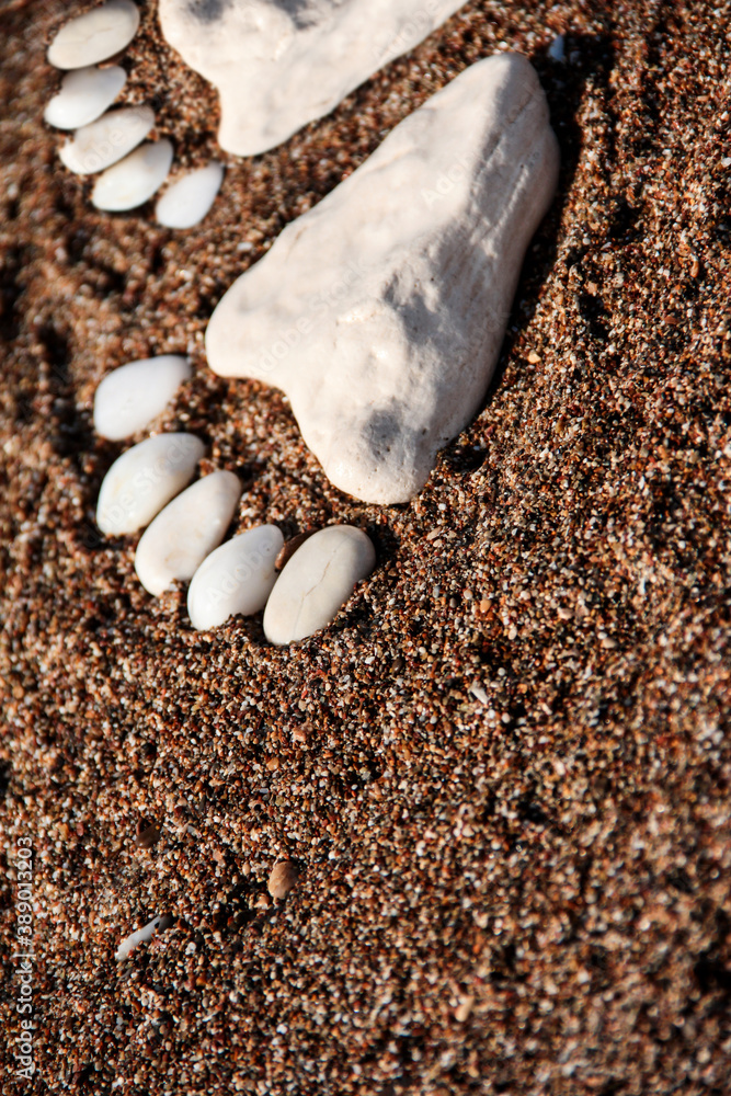 The feet are made of sea stones. Sea background. The feet are made of sea stones. Sea background.