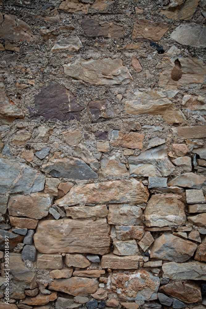Fototapeta premium Photo of an ancient wall in Greece. Background of the old masonry. Vertical orientation.
