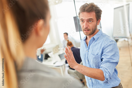 Two business people in dialogue in the hallway