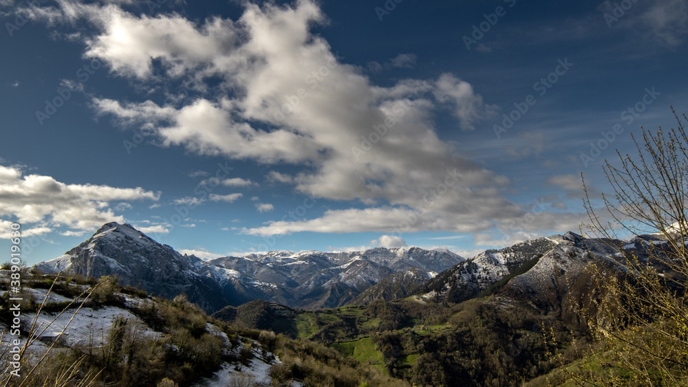 Paisaje de montaña con las cumbres nevadas, día soleado con nubes blancas Paisaje de montaña con las cumbres nevadas, día soleado con nubes blancas