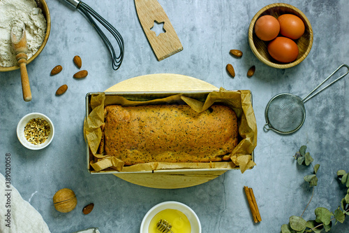 Foto Homemade sugar-free cake with pumpkin, poppy seeds, raisins, almond flour and honey in a baking dish surrounded by ingredients, top view, flat lay, copy space