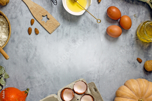Ingredients for baking sugar-free pumpkin baked goods with honey. Flour, pumpkin, eggs, honey, nuts, spices on a gray background, top view, flat lay, copy space