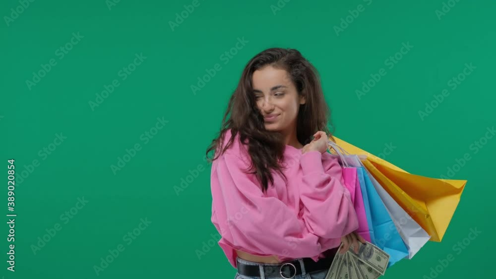 Young girl with shopping bags and bunch of money in the hands on Green Screen, Chroma Key Young girl with shopping bags and bunch of money in the hands on Green Screen, Chroma Key