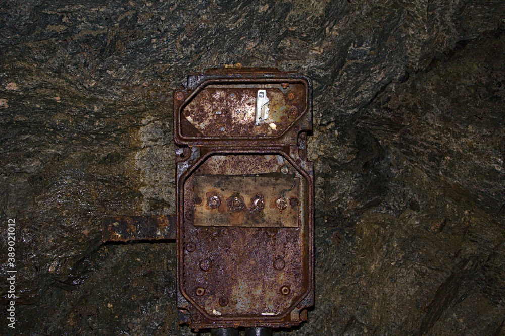 Old and heavily rusted electrical box in an abandoned mine
