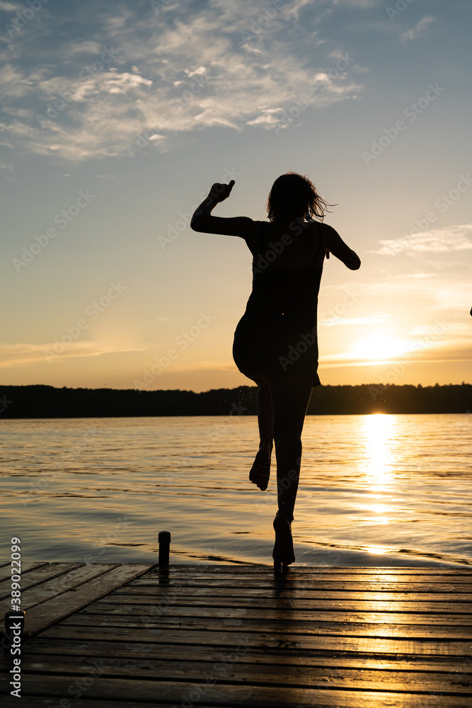 silhouette of a person jumping into the water