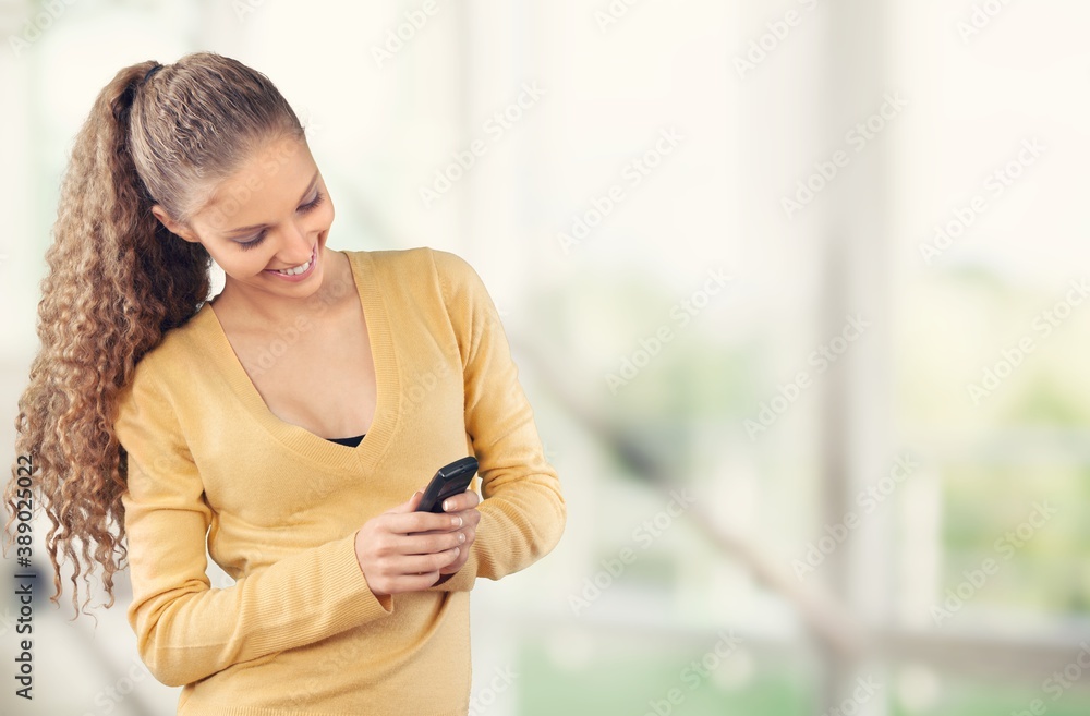 Beautiful young woman using phone at home. Beautiful young woman using phone at home.